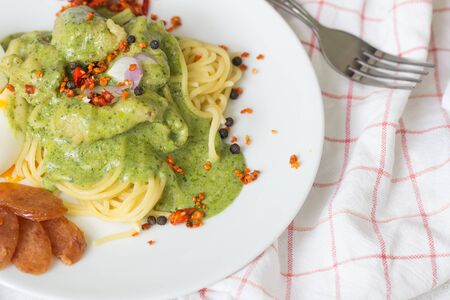 Spaghetti with fish and pesto sauce on white plate. Traditional italian cuisine.の写真素材