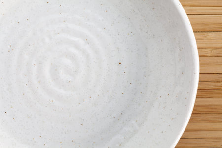 asian design white empty plate on bamboo mat