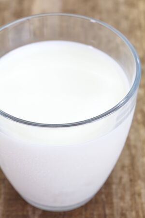 close - up cup of milk on wood tableの写真素材