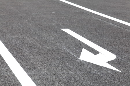 White traffic arrow signage  on an asphalt roadの写真素材