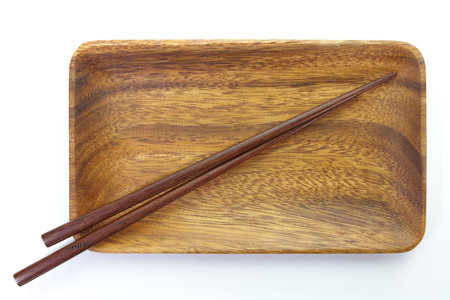 Wood plate and brown wood chopstick on white backgroundの写真素材