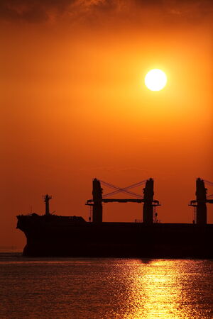 Cargo ship and Beautiful sunset at the oceanの写真素材