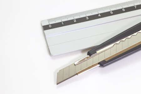 Knife cutter and Stainless steel ruler on white backgroundの写真素材