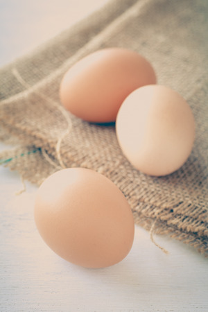 Healthy food brown chicken egg on brown fabric backgroundの写真素材
