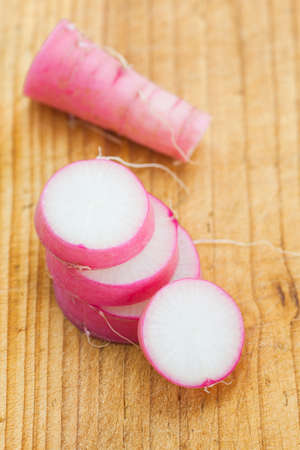 Large and fresh purple daikon radish slice on brown wood backgroundの写真素材