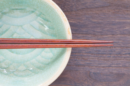 Wood brown chopsticks and celadon green ceramic on wood table backgroundの写真素材