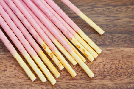 Japanese snack food biscuit stick strawburry coated on wood plateの写真素材