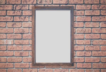 Brown wood picture frame on red brick wallの写真素材