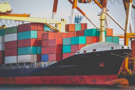 Cargo freight ship with stacked container at harbor terminalの写真素材
