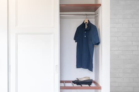 Opened White Built-in wardrobe with men's clothing insideの写真素材