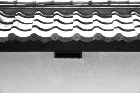 Close - up Japanese roof tile and white stone wall 
