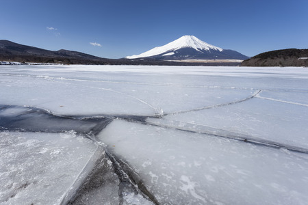 The water in Lake Yamanaka becomes ice during the winter and Mt.Fuji covered in snowの写真素材