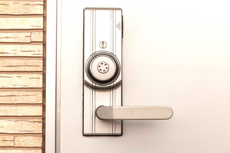 Modern door handle with security system lock on metal door