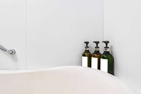 Shower cream and shampoo are placed by the bathtub in the hotel roomの写真素材