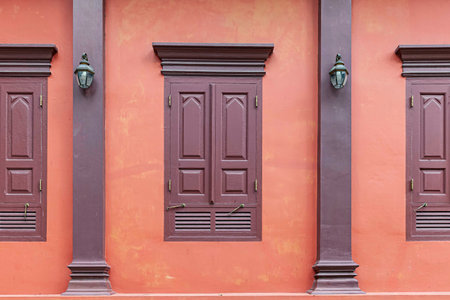 Antique red-brown wooden windows and classic red cement wallの写真素材