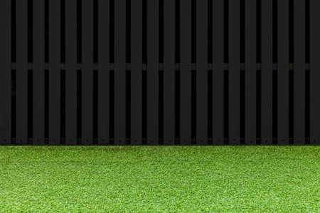 New wooden fence painted black and fresh green lawn floor pattern and background seamless