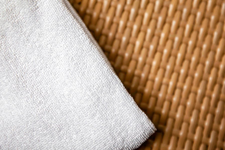 Clean white towels folded on a dark brown wooden table.