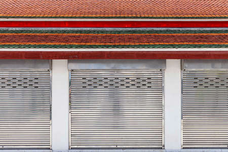 The silver roller shutter door of the store is closedの写真素材