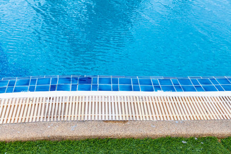 Wide swimming pool and green artificial turf inside the villa