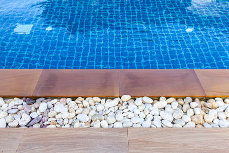 Wide swimming pool and brown stone floor inside the villaの写真素材