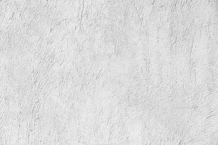 The cement wall is painted white with a pattern texture and background seamlessの写真素材