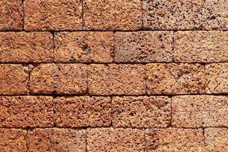 Brown laterite stone wall outside the building at the ancient site