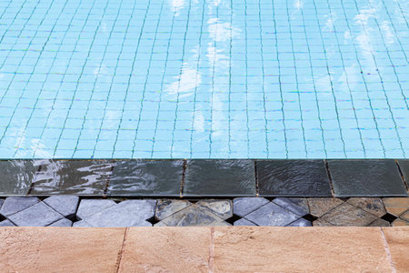 Wide swimming pool and brown stone floor inside the villa