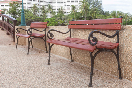Brown iron and wood benches at a shady parkの写真素材