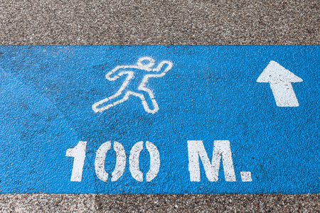 A sign with distance markings on a blue background at a park runway