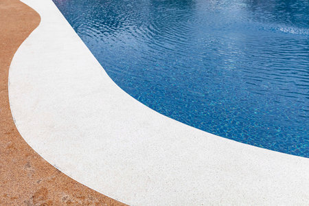 Wide swimming pool and brown stone floor inside the villa