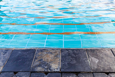 Wide swimming pool and brown stone floor inside the villa