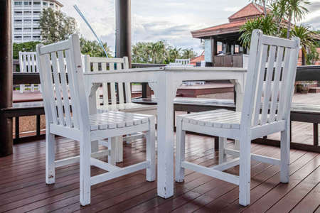 White wooden dining table by the pool inside the resortの写真素材