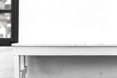 Long white wooden bench and white cement wallの写真素材
