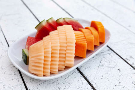 Mixed fruit plate on white wooden tableの写真素材