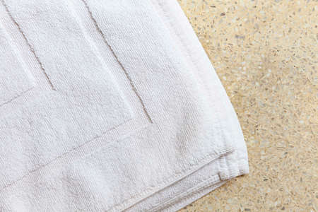 Clean white towels folded on brown stone tableの写真素材