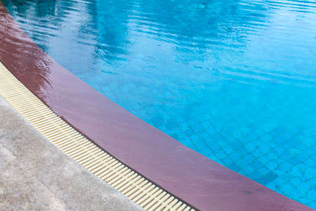 Wide swimming pool and brown stone floor inside the villaの写真素材