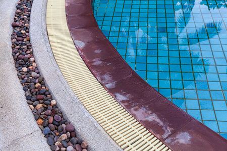 Wide swimming pool and brown stone floor inside the villaの写真素材