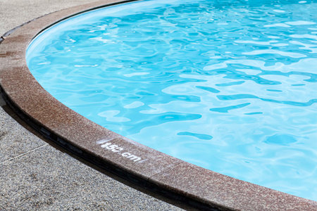 Wide swimming pool and brown stone floor inside the villa