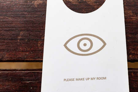 Make up room signs are placed on wooden tables inside the hotelの写真素材