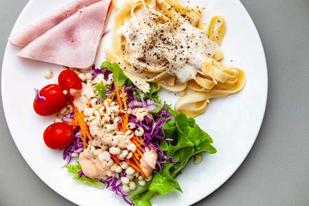 Western breakfast plate, salad, pasta and hamの写真素材