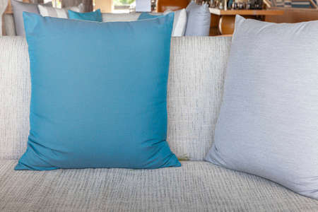 Blue and gray cushions on a gray fabric long sofa in a modern home living roomの写真素材