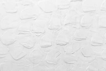 The cement wall is painted white with a circular pattern texture and background seamlessの写真素材