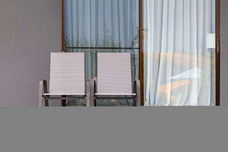 Empty brown plastic sun loungers in front of the rooms at the seaside resortの写真素材