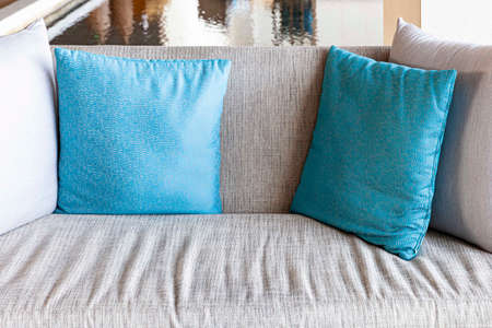 Blue and gray cushions on a gray fabric long sofa in a modern home living roomの写真素材