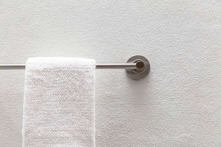 Clean white towels hang on stainless steel rails in the bathroomの写真素材