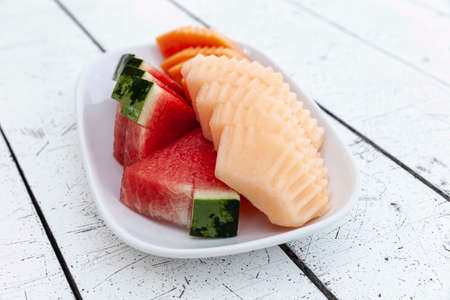 Mixed fruit plate on white wooden tableの写真素材