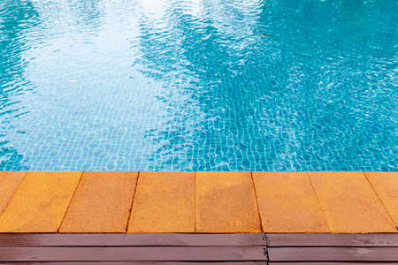 Wide swimming pool and brown stone floor inside the villaの写真素材