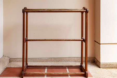 Brown wooden clothes rack placed in front of the houseの写真素材
