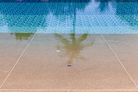 Wide swimming pool and brown stone floor inside the villaの写真素材
