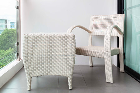 Empty white rattan chair on balcony on high rise buildingの写真素材